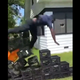 A screencap from a video of a man plummeting from a tower of milk crates while attempting to do the Milk Crate Challenge.